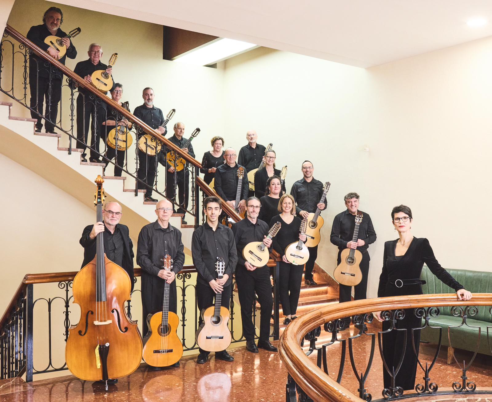 Integrantes de la Orquesta Laudística Daniel Fortea posando en una escalera con sus instrumentos
